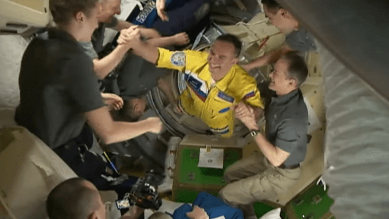 Russian cosmonauts board the International Space Station decked out in Ukrainian colors_62387f82cb95c.png