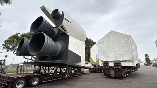 rear view of a full-size space shuttle mockup, with three black engine nozzles and a white tail section