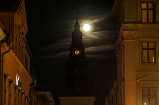 A yellow sphere behind a dark clock tower