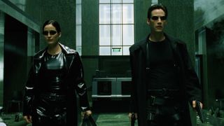 Here we see a man and woman facing the camera, both completely dressed in black leather and wearing black sunglasses.