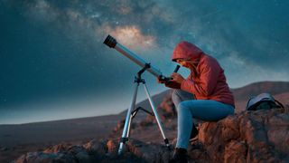 Woman using telescope to see night sky