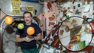 photo of a mustachioed astronaut on the international space station, next to a wall with lots of snacks clipped to it