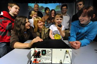 children smile and laugh while talking into a radio handset