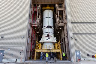 a rocket piece in the doorway of a building surrounded by people