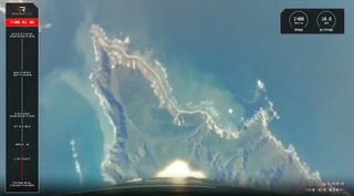 view from a rocket during launch, showing a mountainous peninsula surrounded by the ocean