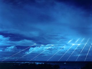 several streaks of light descend from the sky in the far distance