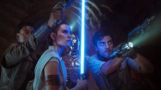 A woman holding a blue lightsaber, flanked on either side by two men pointing blasters at an unseen foe.