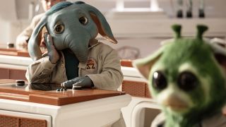 Neel, a blue, elephant-like alien is sat at a desk in school, looking bored in Star Wars: Skeleton Crew.