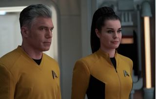 A man and woman suited up in yellow starship uniforms