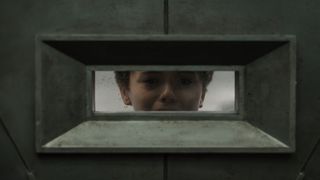 A young boy peers out a vault window