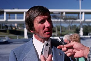 Apollo 15 astronaut Jim Irwin talks to reporters backdropped by the People Mover attraction at Walt Disney World's Tomorrowland in Florida.